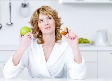 La ragazza sceglie tra la mela e la torta