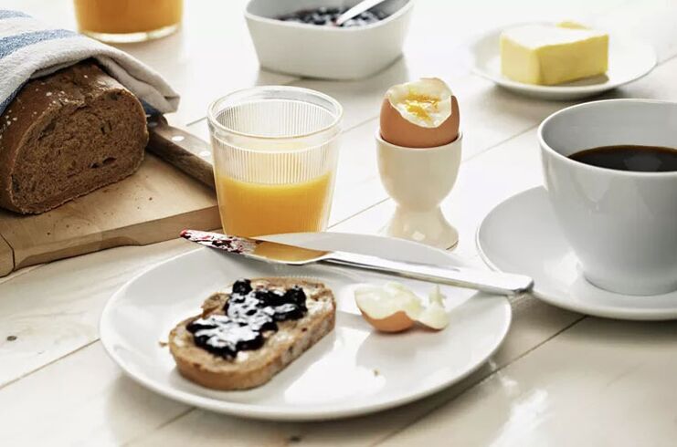 Toast integrali, un uovo e una tazza di caffè colazione con un menu dietetico da 1500 calorie
